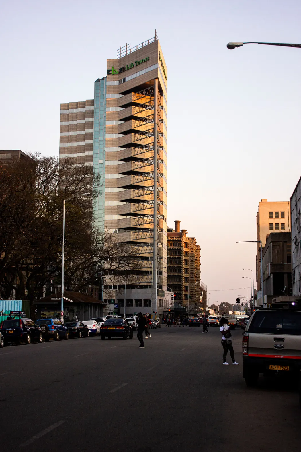 A city street with an ordinary multi-storey building in daylight.
